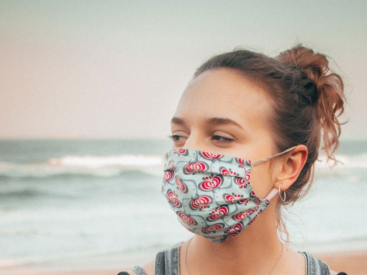Woman wearing a decorated cloth facemask at the beach