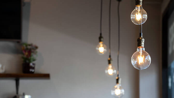 View of multiple Edison-style lightbulbs hanging from a ceiling