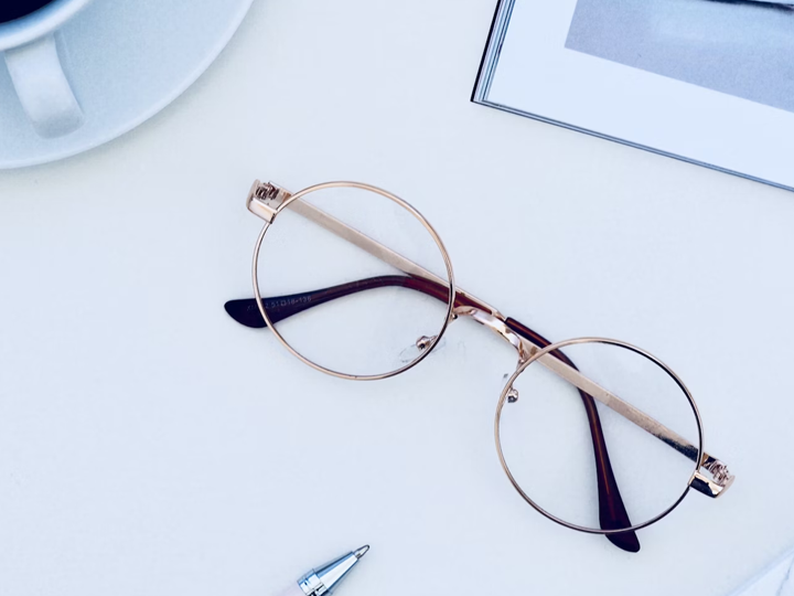eyeglasses with gold frame on white table
