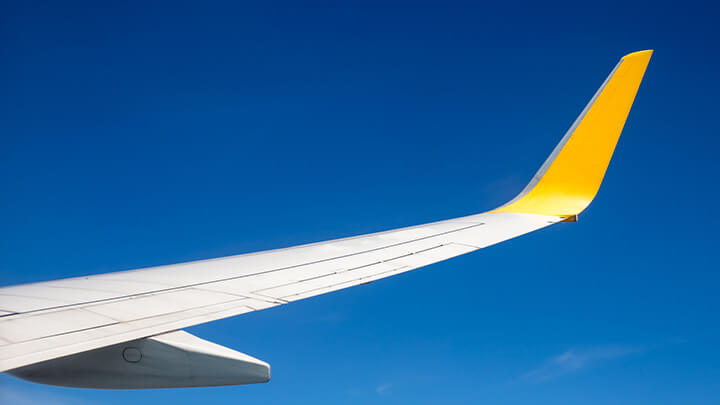 airplane wing against a blue sky