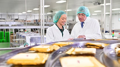 two food industry experts conferring in a food processing plant