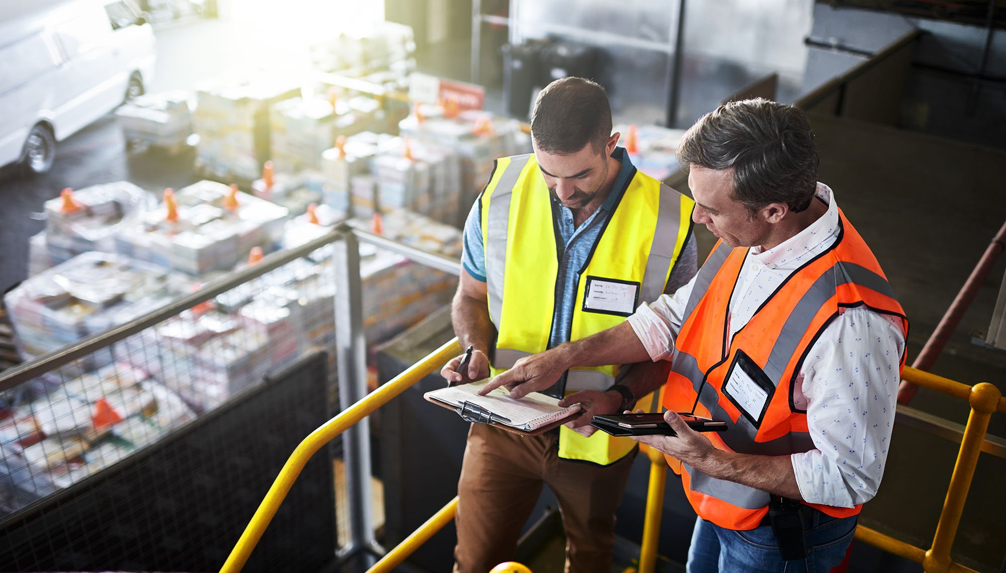 Two men in factory with a clipboard