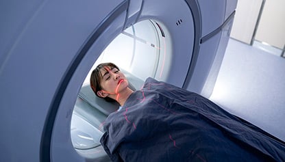 Patient undergoing MRI scan, lying still inside the machine, medical procedure for diagnosis.