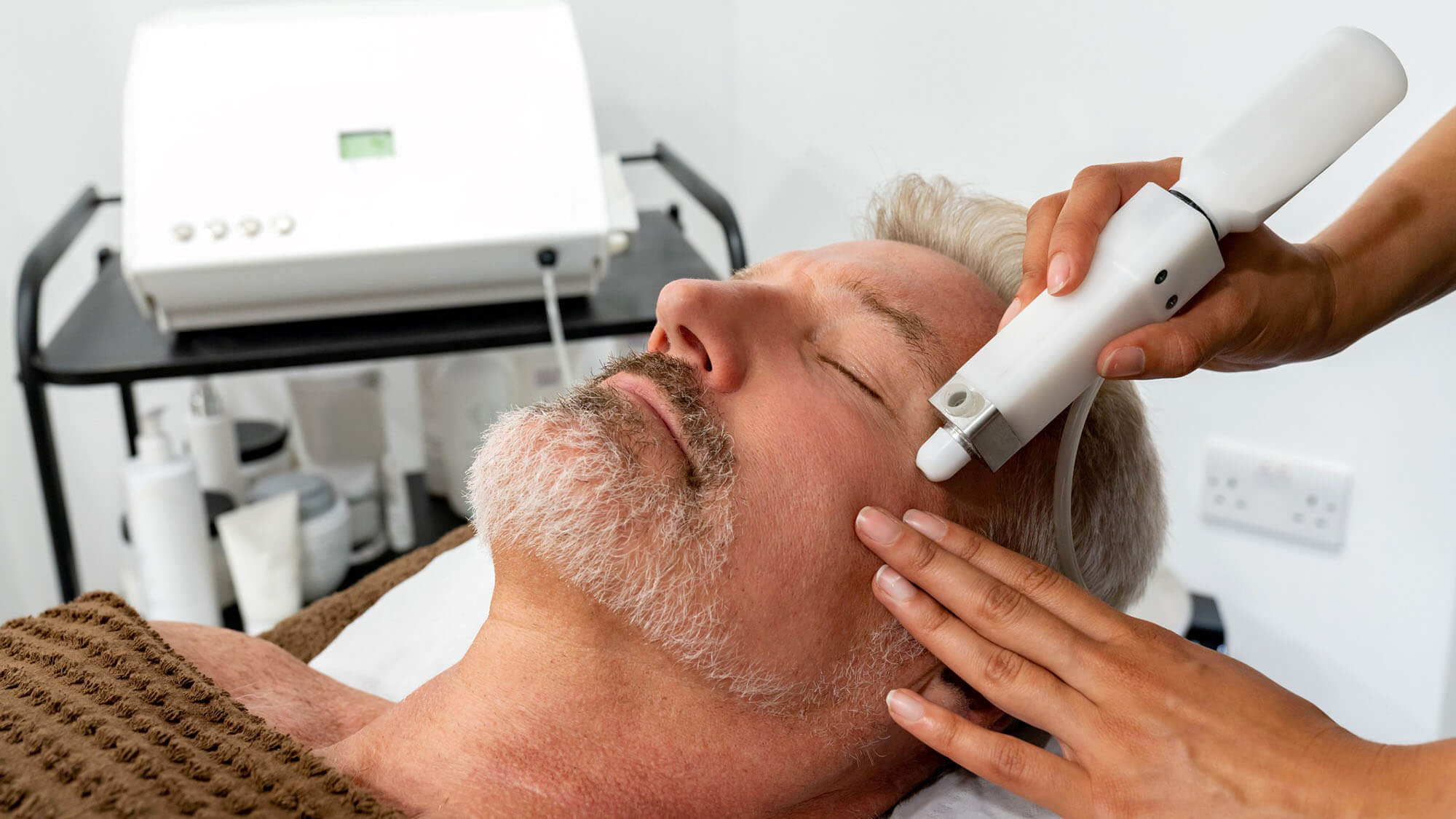 Man at the spa getting a facial laser treatment - stock photo; Handsome man at the spa getting a facial laser treatment - beauty concepts